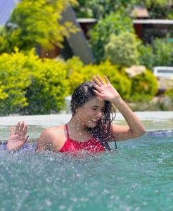 een jonge vrouw zwemt in een zwembad bij The Jungle Mist Resort in Rishīkesh