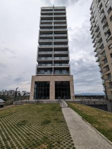 a tall building with a lawn in front of it at Sphera Bagebi Apartment in Tbilisi City