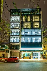 een gebouw met twee auto's ervoor geparkeerd bij Phong Lan Apartments in Hai Phong