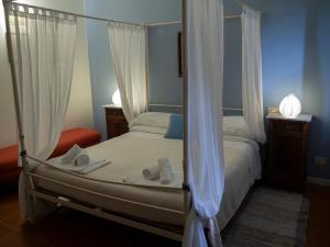 ein Schlafzimmer mit einem Himmelbett und Handtüchern darauf in der Unterkunft Agriturismo La Montagnola in Torgiano