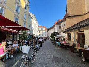 a group of people sitting at tables in a street at Franziskaner Suites #9 in Graz
