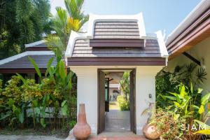 une maison avec une entrée avec des vases devant elle dans l'établissement Villa BangKao 3Br Pool & Walk to Beach, à Nathon Bay