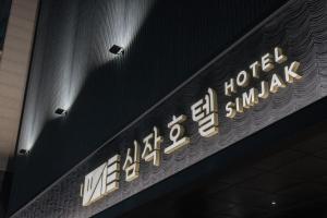 ein Schild für ein Hotel in einem Gebäude in der Unterkunft Simjak Hotel Dongtan By Aank in Hwaseong