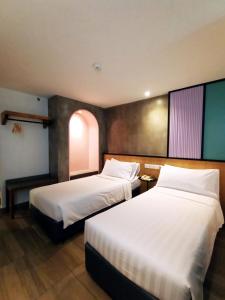 a hotel room with two beds and a window at The Bayou Hotel Langkawi in Pantai Cenang