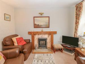 a living room with a couch and a fireplace at Blacksmith Cottage in Appleby