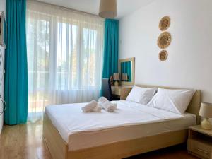a bedroom with a large bed with towels on it at Europe Holiday Apartments First Sea Line Coast in Pomorie +125 photos