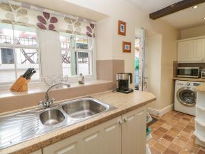 cocina con fregadero y encimera en Blacksmith Cottage en Appleby