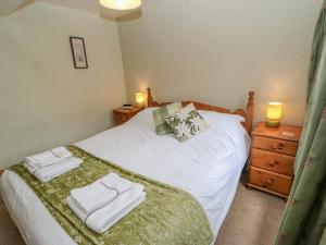 a bedroom with a bed with two towels on it at Blacksmith Cottage in Appleby