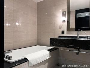 ein Badezimmer mit einer Badewanne und einem Waschbecken in der Unterkunft Talmud Hotel Kaohsiung LoveRiver in Kaohsiung