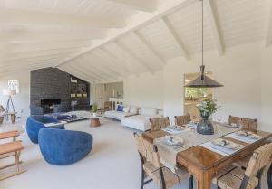 ein Wohnzimmer mit einem Holztisch und blauen Stühlen in der Unterkunft 3900 Palm House on Cabrillo home in Pebble Beach