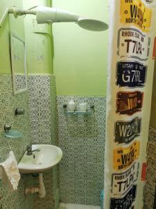 a bathroom with a sink and signs on the shower curtain at Hermoso departamento en el centro ciudad, casa M MELGAR in Arequipa