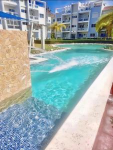 a pool with blue water and white buildings at Beautiful Penthouse in Punta Cana & Close Beach in Punta Cana