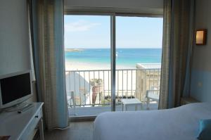 キブロンにあるHôtel des Druidesのベッド付きのホテルルームで、海の景色を望めます。