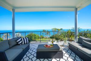 un patio con sofás y vistas al océano. en Welcome Homestay Gurambai en Darwin