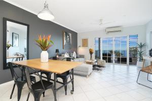 a dining room and living room with a table and chairs at Welcome Homestay Gurambai in Darwin