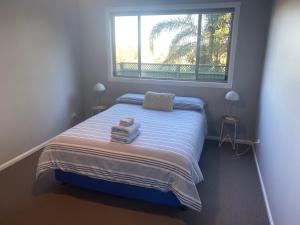 una camera da letto con un letto e una grande finestra di Central Oasis a Coffs Harbour
