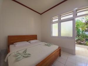a bedroom with a bed and a window at Bajo Hotel in Labuan Bajo