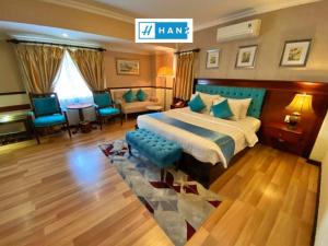 a hotel room with a bed and a living room at HANZ Vuon Saigon Hotel & Spa in Ho Chi Minh City