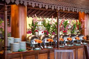 a buffet with bowls and plates and flowers at Royal Crown Hotel & Spa in Siem Reap