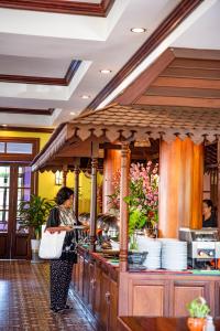 a woman standing at a counter in a kitchen at Royal Crown Hotel & Spa in Siem Reap