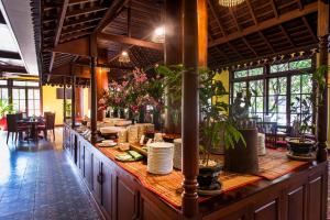 a restaurant with a long counter with plates and plants at Royal Crown Hotel & Spa in Siem Reap