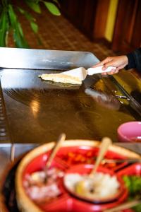 a person is holding a slice of pizza on a table at Royal Crown Hotel & Spa in Siem Reap