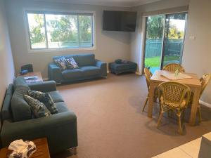 a living room with a couch and a table at Central Oasis in Coffs Harbour