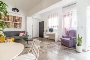 a living room with a couch and a table and chairs at Evangeline City Center Apartment AC/WiFi in Heraklio