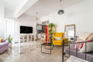 a living room with couches and a tv at Evangeline City Center Apartment AC/WiFi in Heraklio