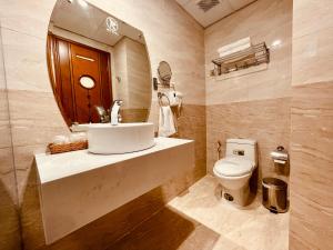 W łazience znajduje się umywalka, toaleta i lustro. w obiekcie KEN HOTEL w Ho Chi Minh