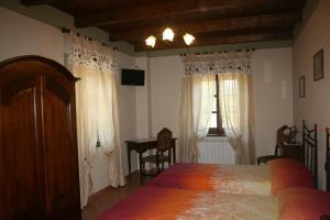 een slaapkamer met een bed, een tafel en een raam bij Agriturismo Cascina Nuova in Barge