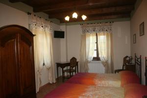 sypialnia z łóżkiem, stołem i oknem w obiekcie Agriturismo Cascina Nuova w mieście Barge