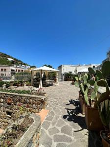 un patio con macetas y sombrilla en Lunaponzese-Ponza centro, en Ponza