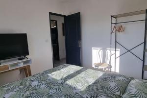 a bedroom with a bed and a flat screen tv at Maison Bohême" entre Collègues ou Famille - Piscine Jacuzzi jusqu'à fin septembre in Saint-Seurin-sur-lʼIsle +30 photos