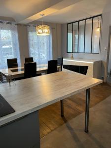 Maison centre ville في فير: غرفة طعام مع طاولة وكراسي خشبية كبيرة