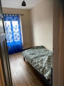 sypialnia z łóżkiem i niebieskimi drzwiami w obiekcie Maison centre ville w mieście Vire