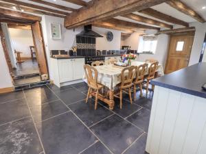 cocina grande con mesa y sillas en Satterthwaite Farmhouse - Sleep 8 en Grizedale