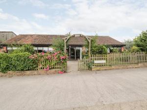 una puerta de madera a una casa con flores en The Barn en Chippenham