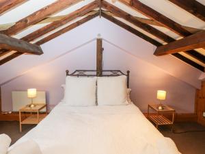 a bedroom with a white bed with two lamps at The Barn in Chippenham