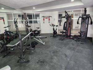 une salle de sport avec plusieurs tapis de course et vélos d'exercice dans l'établissement Nuevo y amplio departamento con alberca y seguridad en el centro de Guadalajara, à Guadalajara