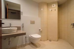 ein Bad mit einem WC, einem Waschbecken und einer Dusche in der Unterkunft Emerald Hotel in Aizawl