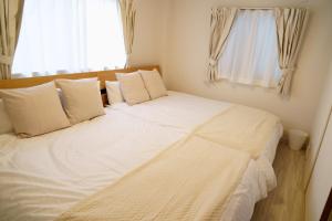 a large white bed in a room with a window at Liaison Court Universal Gateway in Osaka