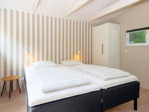 ToftlundにあるThree-Bedroom Holiday home in Toftlund 15のストライプの壁の客室のベッド1台