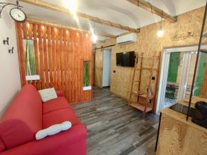een woonkamer met een rode bank en een tv bij Ragusa 2 al mare in Marina di Ragusa