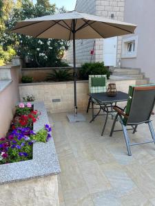 patio con tavolo, ombrellone e fiori di MARILU a Korčula