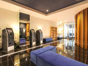 una sala de espera con un sofá azul en un edificio en HOTEL LiVEMAX Osaka Yodoyabashi, en Osaka