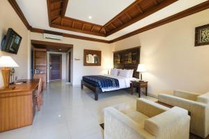 ウブドにあるBhuwana Ubud Hotel and Farmingのベッドルーム1室(ベッド1台付)、リビングルームが備わります。