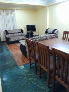 ein Wohnzimmer mit einem Tisch und einem Sofa in der Unterkunft Apartment Rupas in Kathmandu