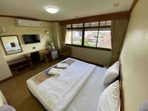 sypialnia z dużym białym łóżkiem i oknem w obiekcie Phuphanplace Hotel w mieście Ban Phang Khwang Tai