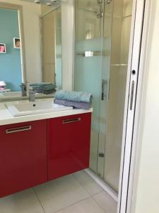 La salle de bains est pourvue d'un lavabo rouge et d'une douche. dans l'établissement L’échappée belle Au cœur de la Provence verte, à Saint-Maximin-la-Sainte-Baume